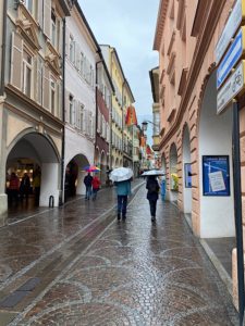 Es regnet in Meran. Leute tragen Regenschirme